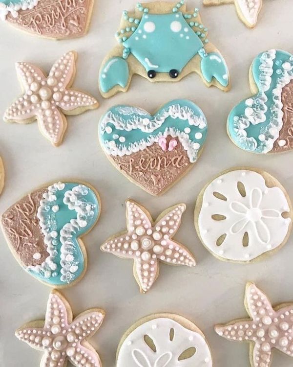 decorated cookies are arranged in the shape of hearts and seashells on a table