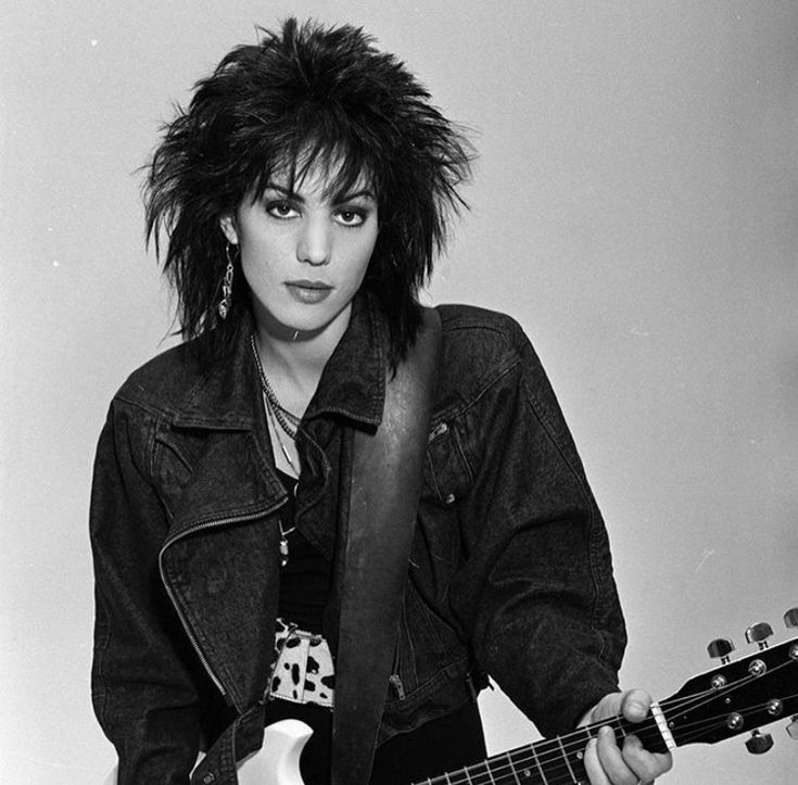 a black and white photo of a woman holding a guitar