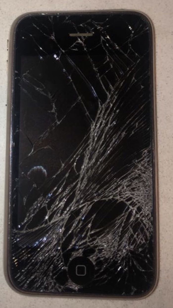 an iphone that has been cracked and is sitting on the table