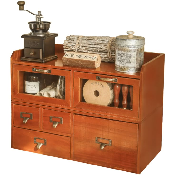 an old wooden cabinet with drawers and various items on top, including a grinder