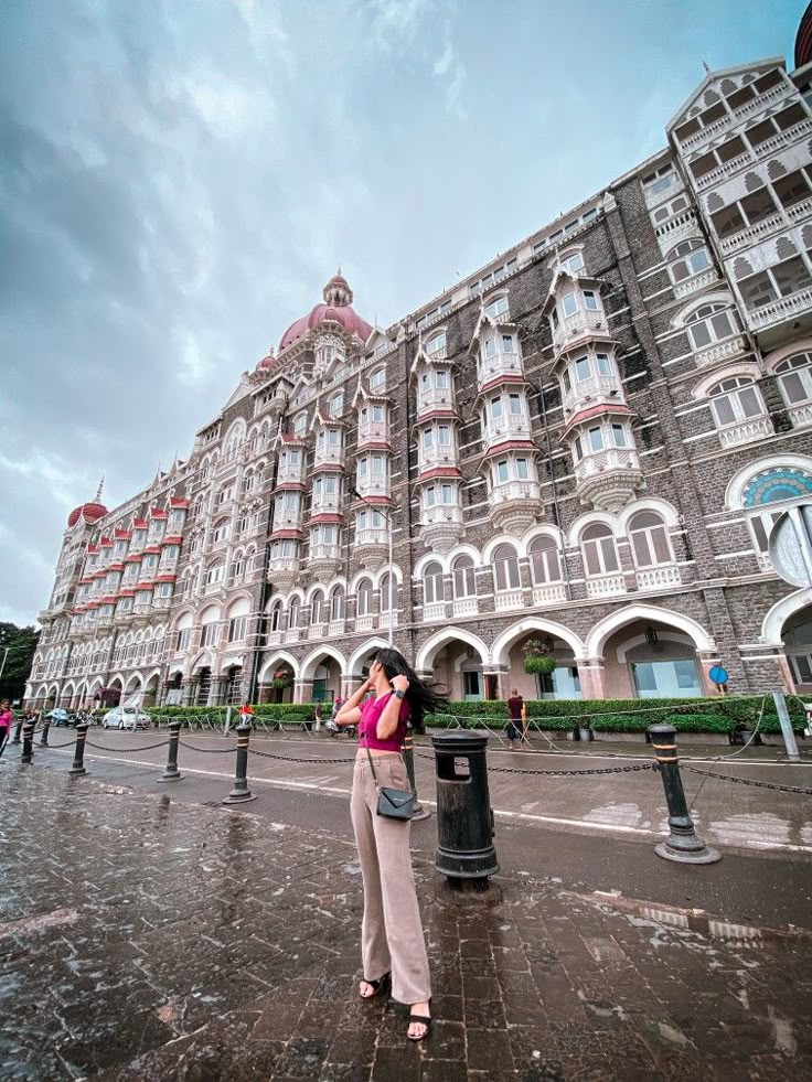 a woman standing in front of a large building