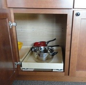 an open cabinet with pots and pans in it