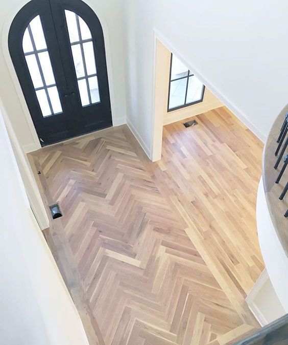 an aerial view of a house with wood floors and black front door leading to another room