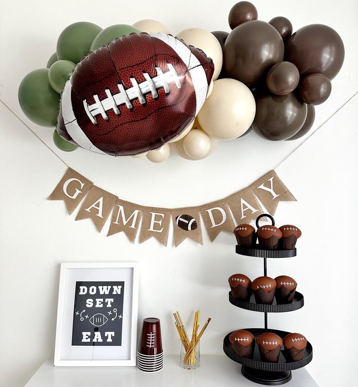 a football themed birthday party with balloons and desserts on the table, along with game day decorations