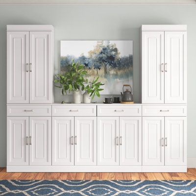 a large white cabinet sitting on top of a wooden floor next to a blue rug