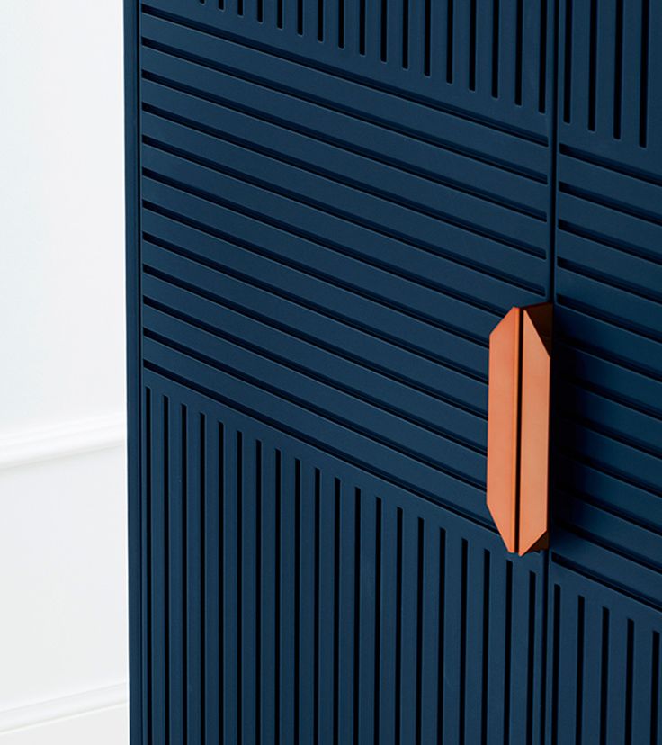 an orange object is mounted on the side of a blue wall with vertical slats