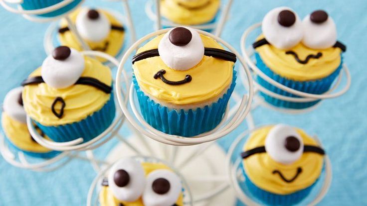 cupcakes decorated with yellow and blue frosting are arranged in the shape of bees