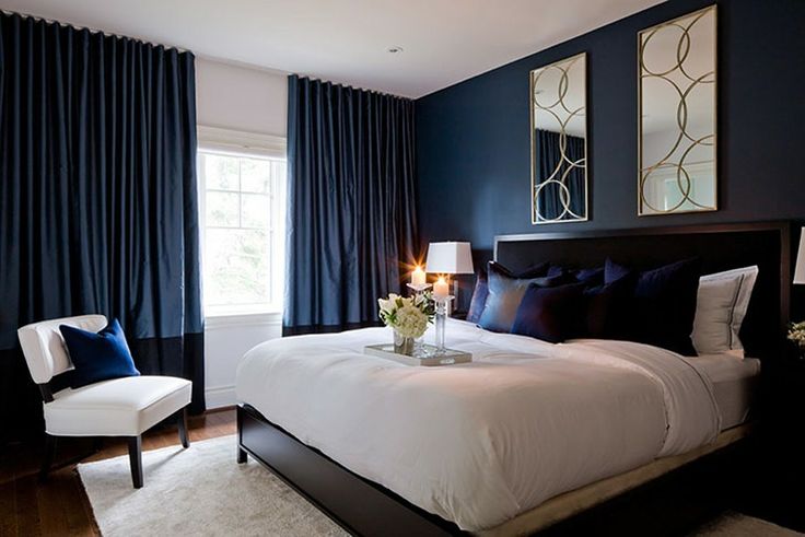 a bedroom with dark blue walls and white bedding