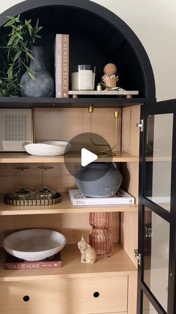 a book shelf with books and vases on it