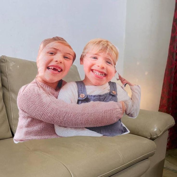 two young boys sitting on top of a couch with their arms around each other's shoulders