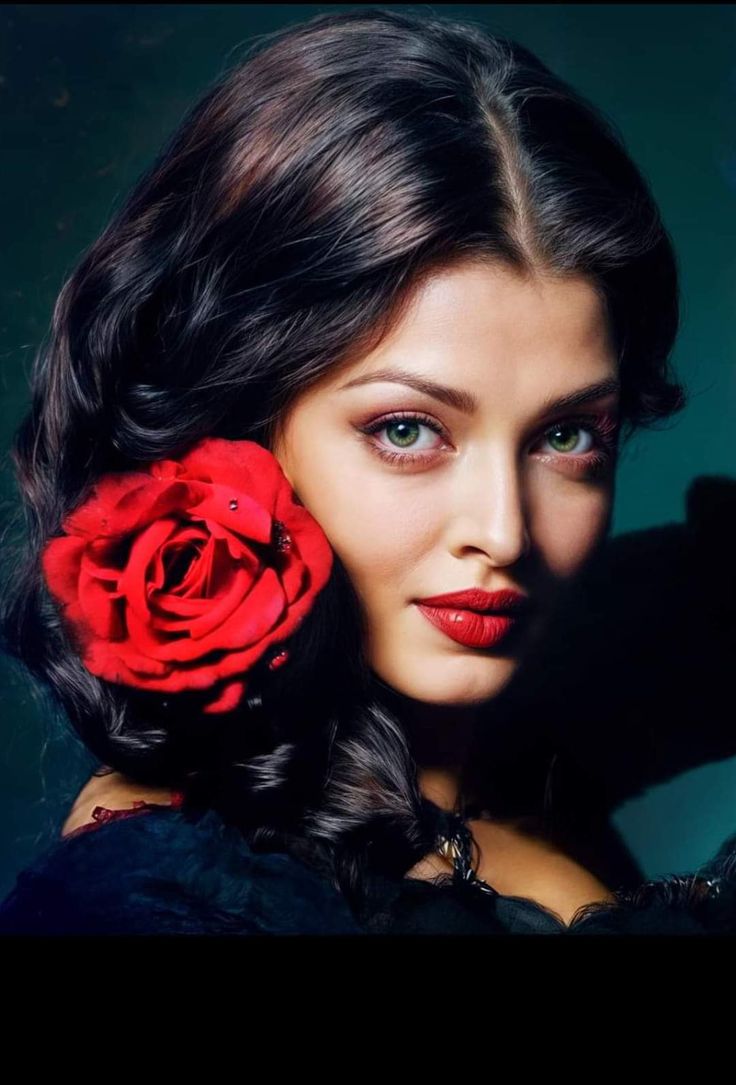 a woman with long dark hair and a red rose in her hair is posing for the camera