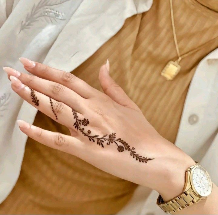 a woman's hand with a henna tattoo on her left palm and wrist