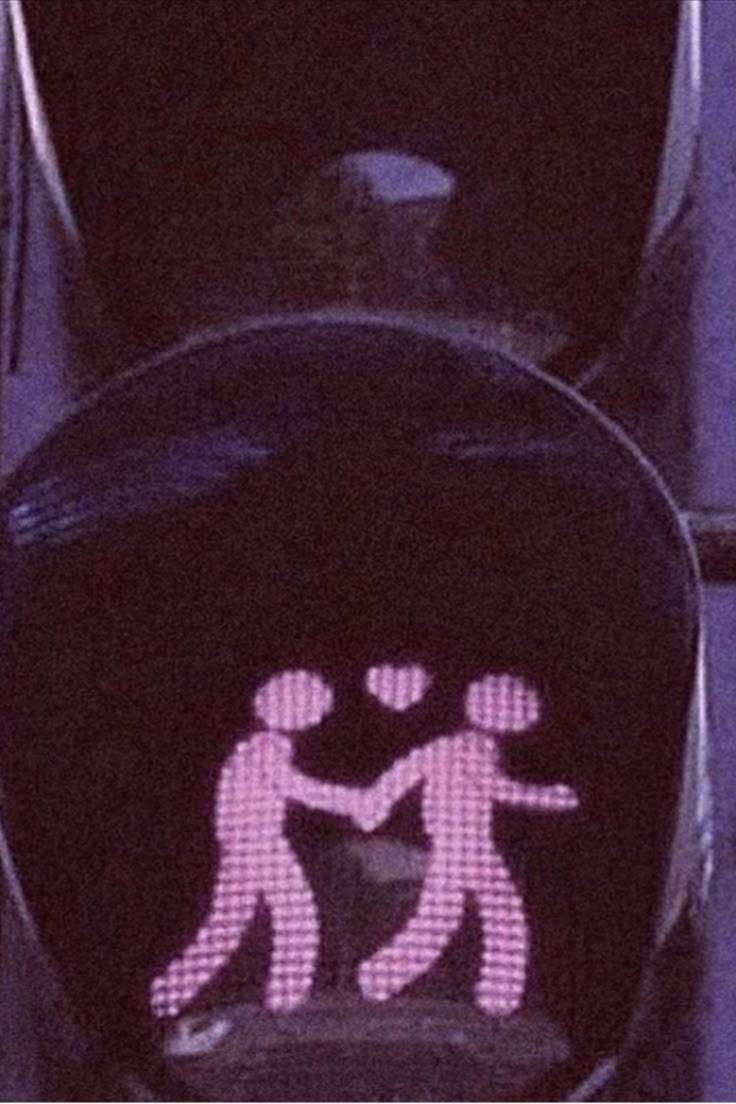 a traffic light with an image of two people holding hands on the cross walk signal