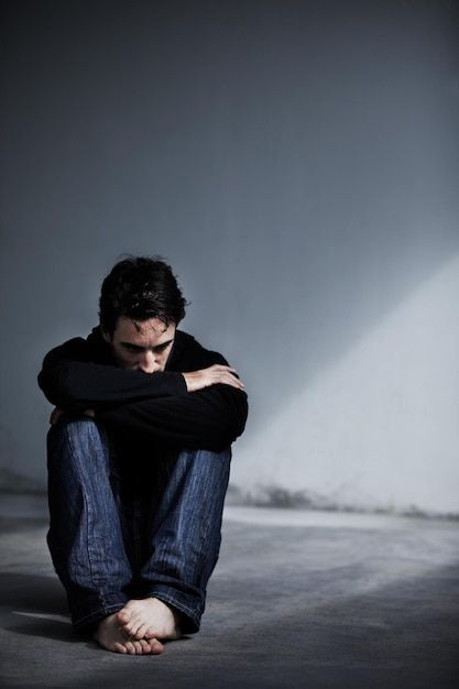 a man sitting on the floor with his arms crossed