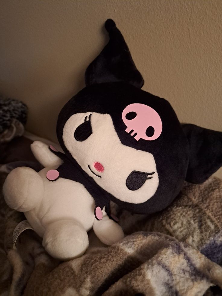 a black and white stuffed animal with pink eyes