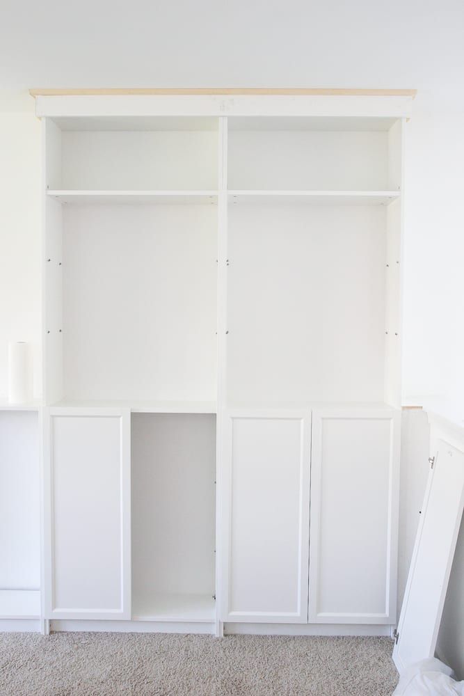 an empty room with white shelves and carpet