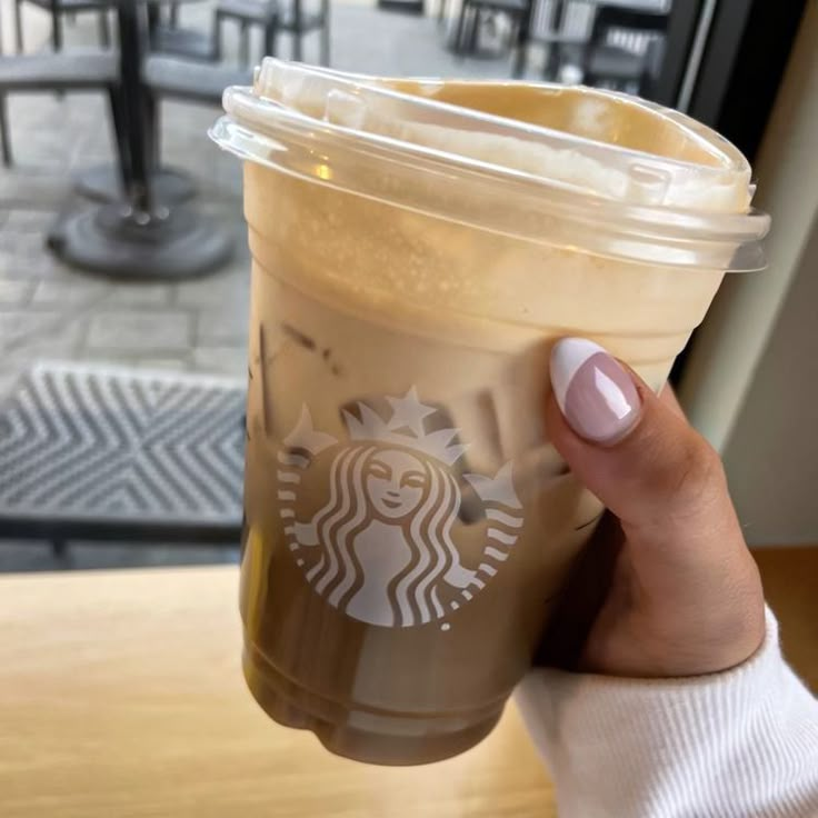 a woman holding up a cup of coffee