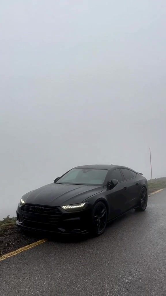 a black car is parked on the side of the road