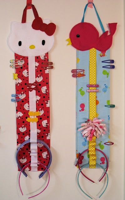 two hello kitty door hangers are hanging on the wall and one is holding a bird