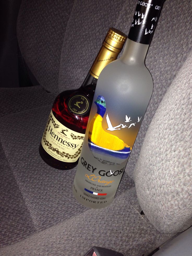 two bottles of alcohol sitting on the back seat of a car, next to each other