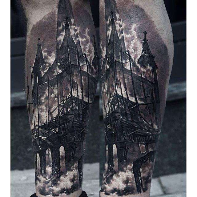 the legs are covered in black and grey ink with an image of a lighthouse on it