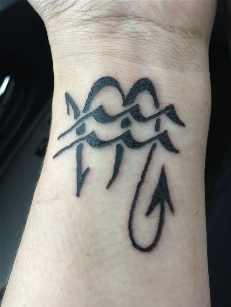 a wrist tattoo with an arrow on it