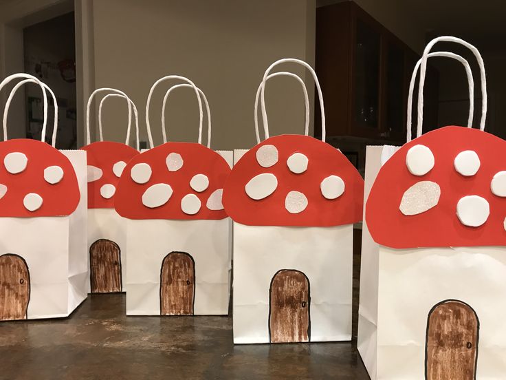 four bags with red and white designs on them are lined up in the shape of mushrooms