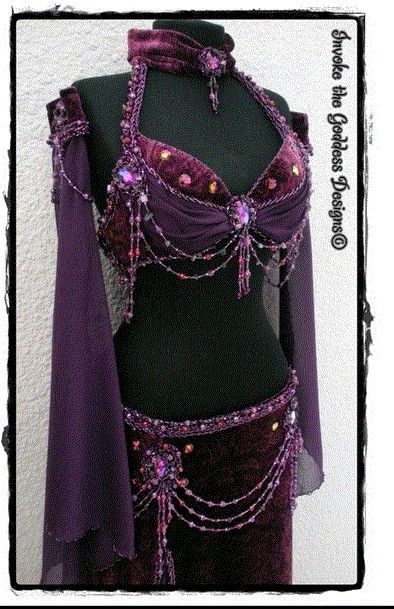 a woman's belly dance costume with purple sequins and beads on it