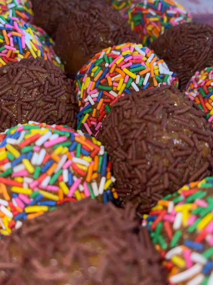 many chocolate covered donuts with sprinkles on them