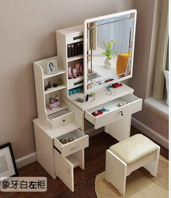 a pink and white desk with drawers, mirror and stools in front of a window