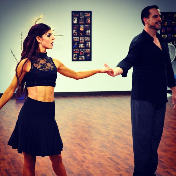 a man and woman dancing in a dance studio