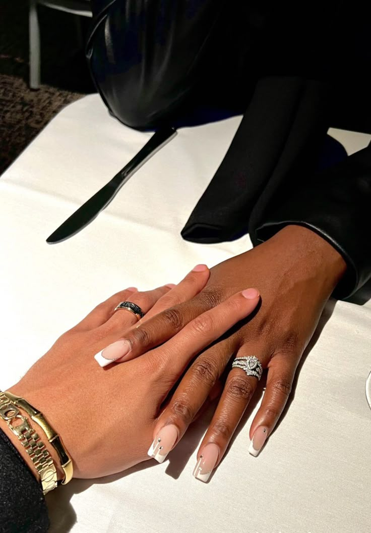 two people holding each other's hands at a table with wine glasses and napkins on it