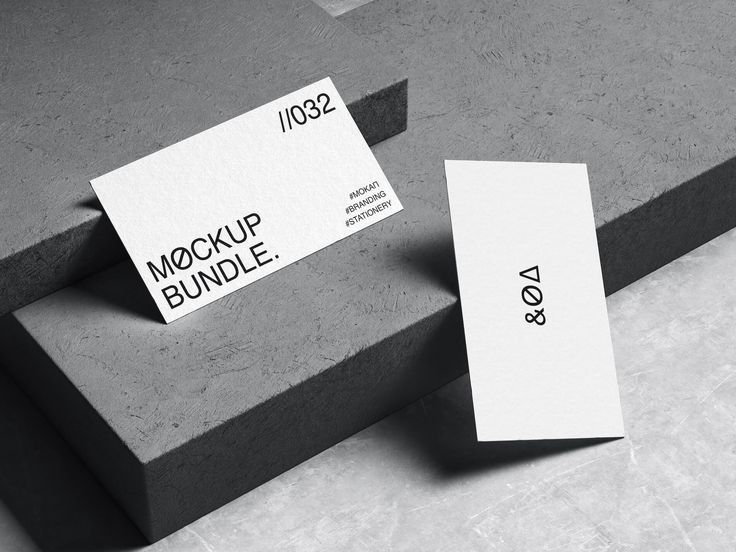 two business cards sitting on top of some concrete blocks with the words mock up bundle