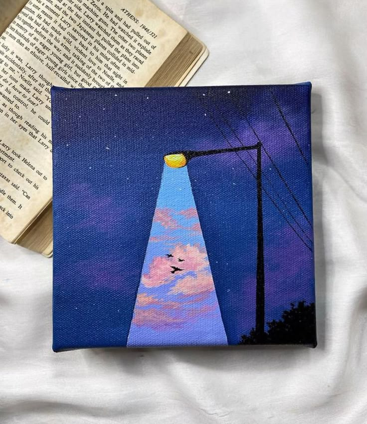 a painting of a street light on top of a book next to an open book