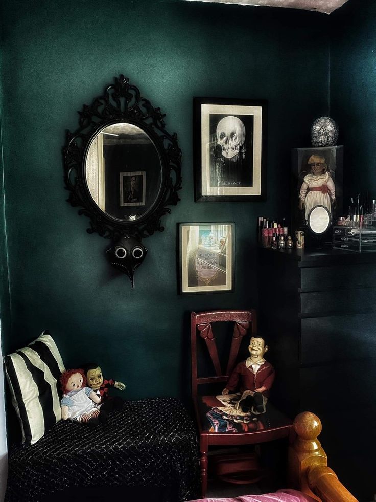 a room with green walls and pictures on the wall, including a small doll sitting in a chair