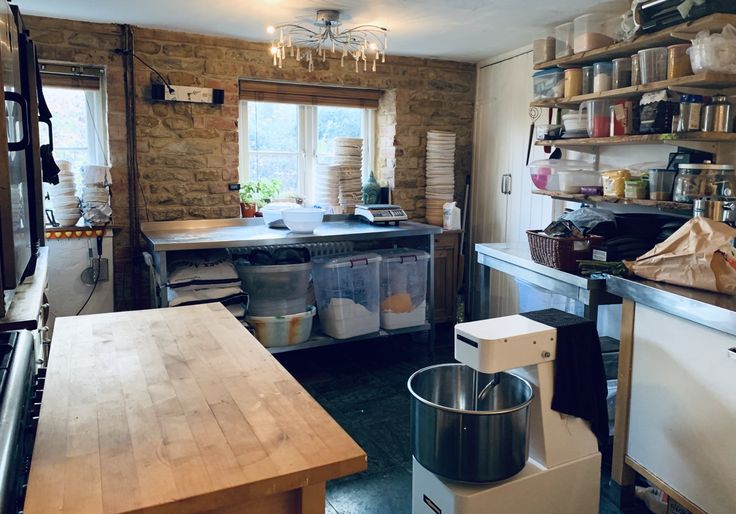 a kitchen filled with lots of clutter and cooking utensils on the counter