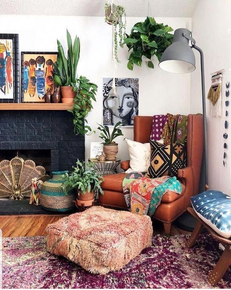 a living room filled with lots of furniture and plants on top of a fireplace mantel