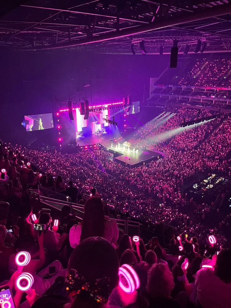 a large crowd at a concert with bright lights