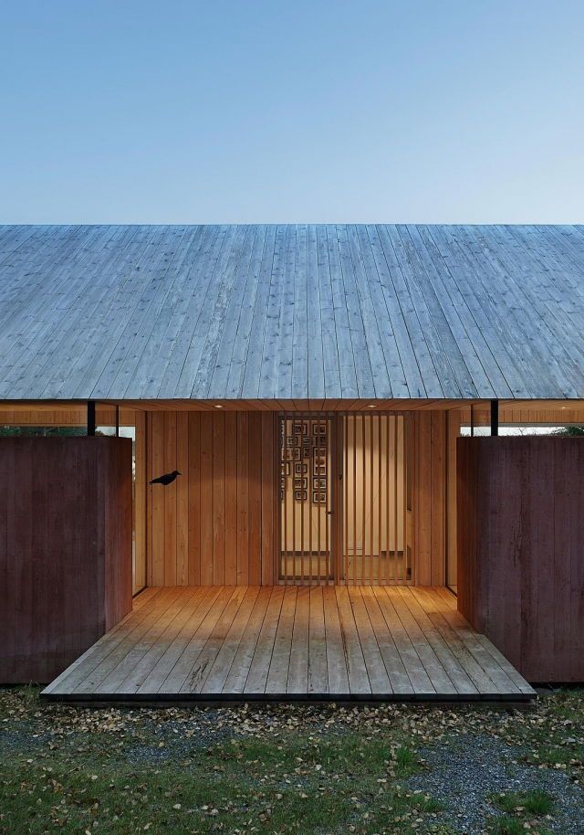 an open wooden door on the outside of a building with wood flooring and walls