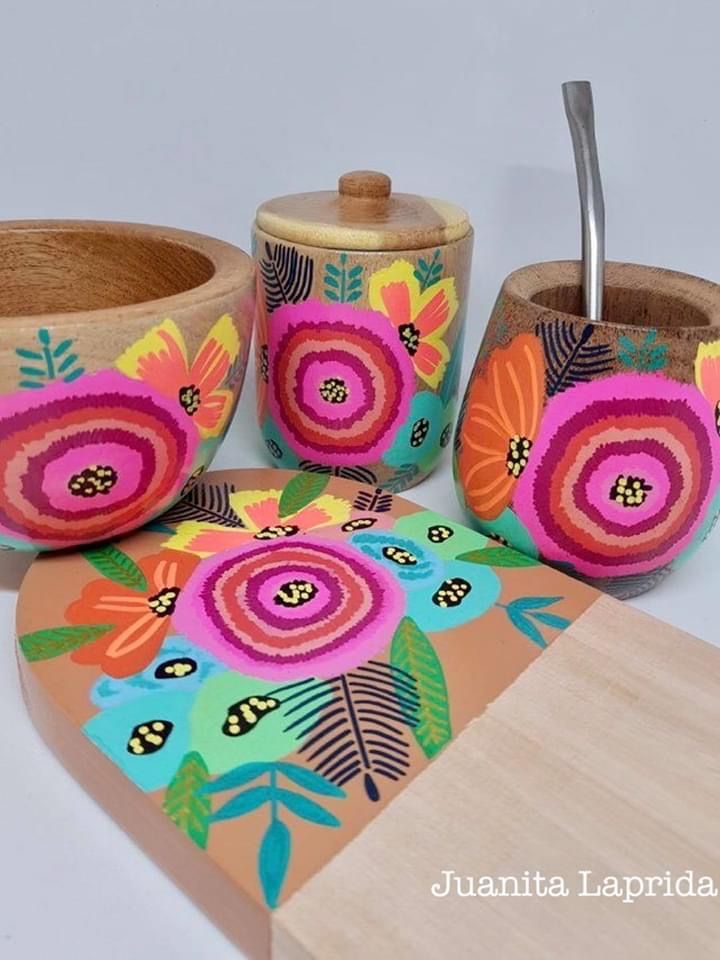 an assortment of colorful painted wooden bowls and spoons