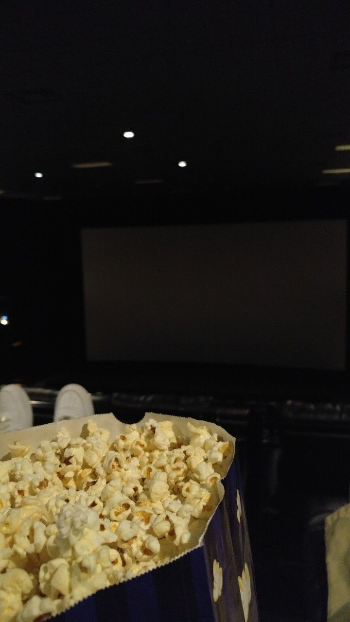 a popcorn bag sitting on top of a table in front of a movie projector