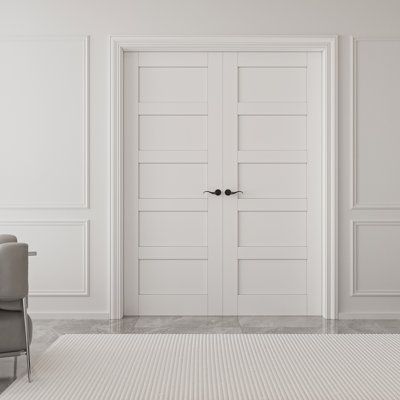 an empty white room with two chairs and a rug on the floor in front of it