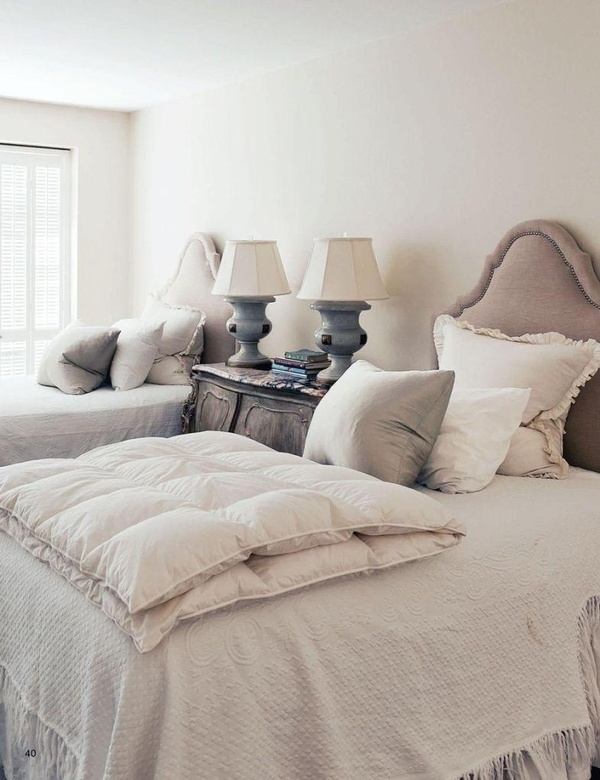 two beds with pillows and blankets on them in a bedroom next to a large window