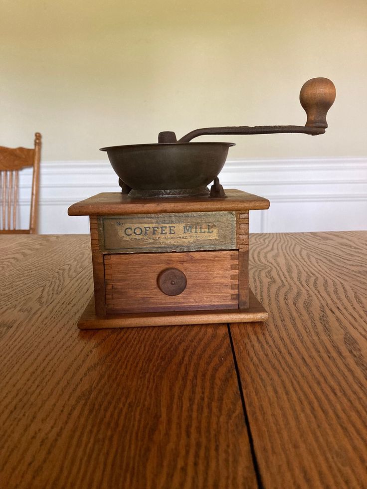 an old fashioned coffee mill on a wooden table