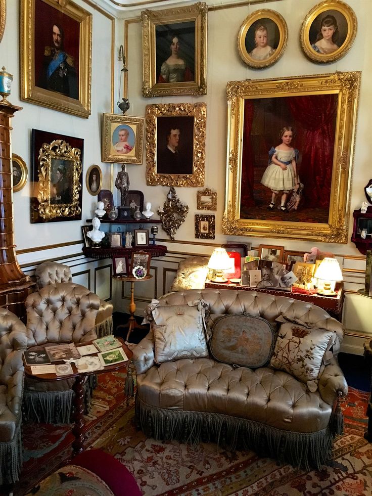 a living room filled with furniture and paintings on the wall