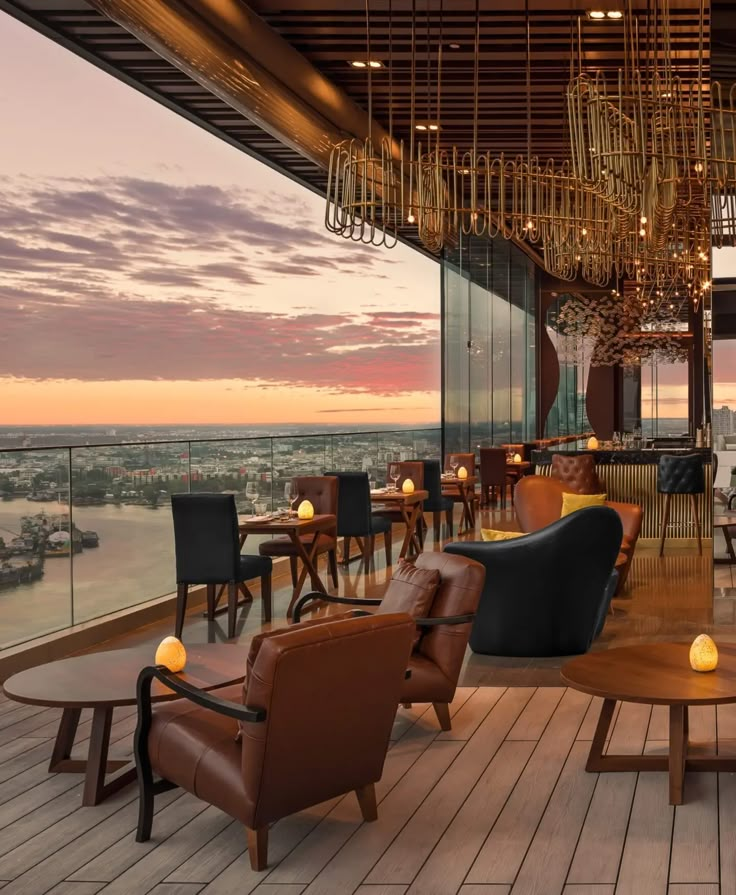 an outdoor restaurant overlooking the city at sunset