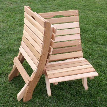 a wooden lawn chair sitting on top of a lush green field