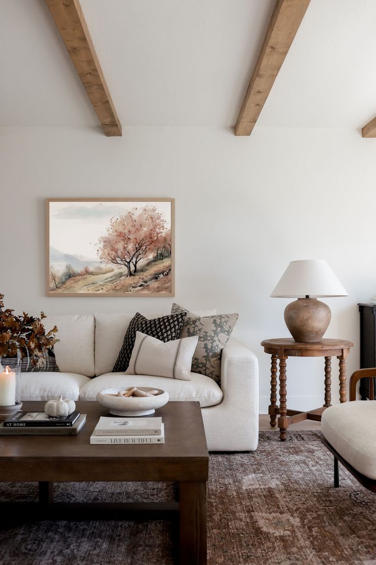 a living room filled with furniture and a painting on the wall above it's coffee table