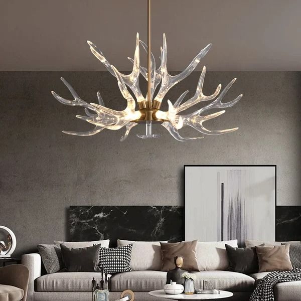 a living room filled with furniture and a chandelier hanging over the top of it