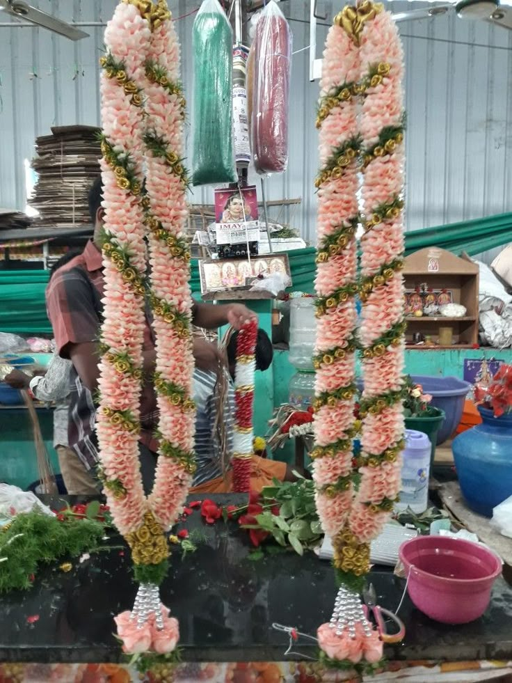 two tall pink flowers are on display in a market